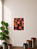 A Poster print with a .5-inch white border featuring an abstract art piece displayed on a wall in a styled room with a plant, paint cans, and window shadows in the display. The art image has blue abstract clusters laying on top of an orange background with black abstract line art. There are also gold-colored abstract clusters that have a red dot stroke like accent in the middle of each cluster. Another element is the pop art pink flowers with a red border on the petals and a gold core with a red dot.